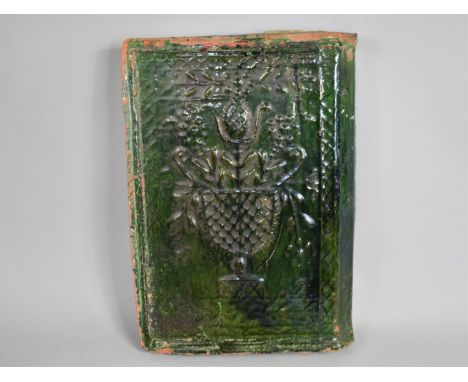 A 19th Century Green Glazed Terracotta Corner Tile Decorated in Relief with Urn of Flowers, 31cms by 21cms 