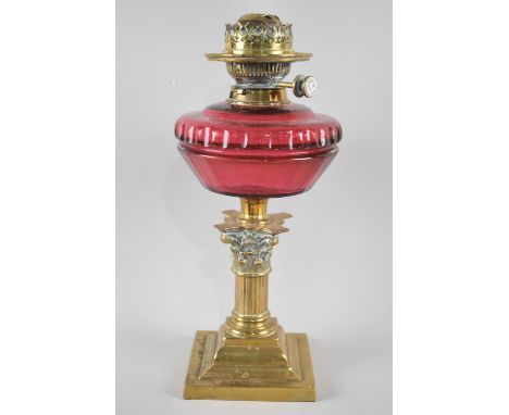 A Late 19th Century Brass and Cranberry Glass Oil Lamp, The Support in the Form of The Top Section of a Corinthian Column, St