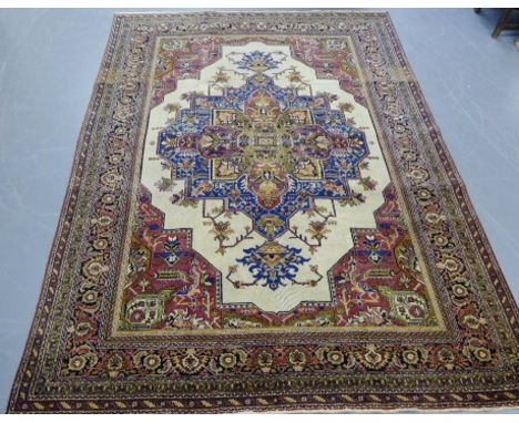 A Heriz style carpet having a multi floral border enclosing a floral medallion on a red field, 336 x 334cm 