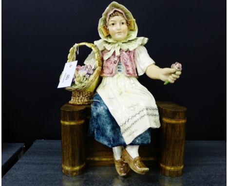 Continental pottery figure of a Dutch Flower Seller, modelled seated on a wooden bench, 45cm high