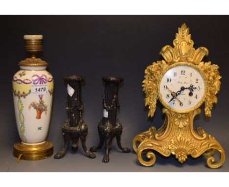 A Henry Moore gilt metal Empire style mantel clock;  a gilt metal and porcelain lamp hand painted with flower baskets and rib
