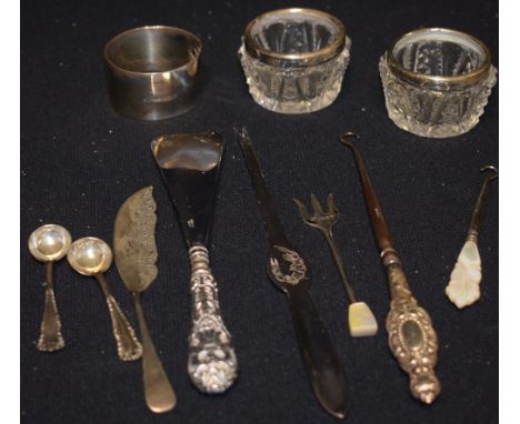 A silver napkin ring; a silver butter knife; a pair of silver mounted table salts with spoons; a silver hafted button hook; e