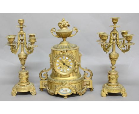 FRENCH GILT BRASS AND PORCELAIN CLOCK GARNITURE, the dial with blue enamelled numerals on a brass eight day movement hourly s