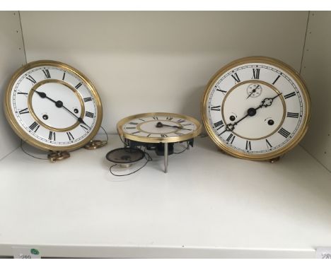 * 4 x Shelves of various clock spares, built clock movements with front dial plate arms.  Boxed clock movements, various smal