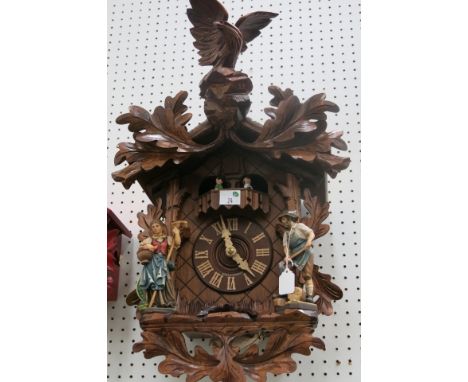 * German Large wooden cased cuckoo clock with figure mounts and Eagle finial;  weight driven mechanical movement 