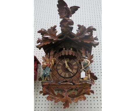 * German large wooden cased cuckoo clock with weight driven mechanical movement, figure mount and eagle finial 