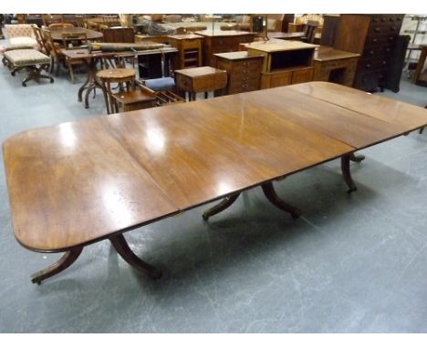 George III mahogany triple pedestal dining table, the reeded edge top with curved corners on turned reeded columns with downs