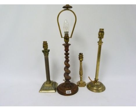 Barley twist wood candlestick later converted to take lamp; together with three brass column lamps.