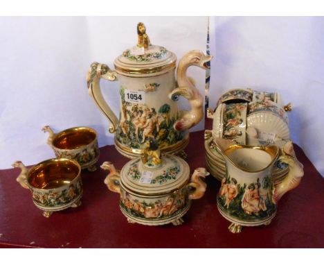 A vintage Capodimonte coffee set decorated in typical style with moulded figural scenes, comprising coffee pot, cream jug, su