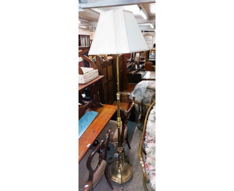 A Victorian style brass telescopic standard lamp, set on a circular base with decorative triple bracket supports - with shade