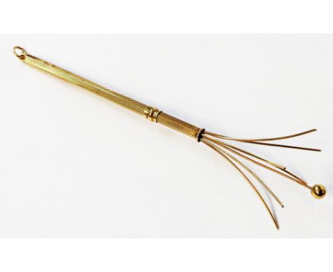 A 375 (9ct.) gold telescopic swizzle stick with engine turned decoration and suspender loop