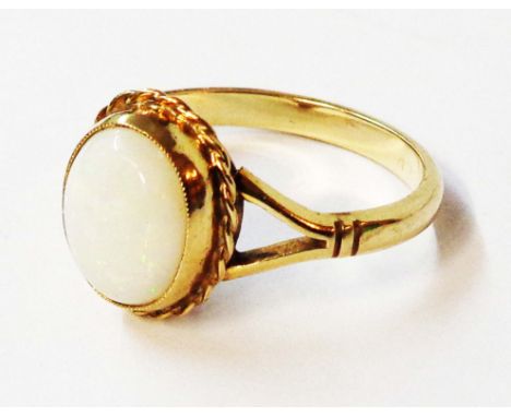 A marked 9ct. yellow metal ring, set with milky opal oval cabochon - size P 1/2