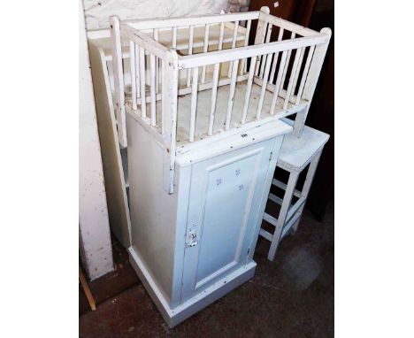 A pot cupboard enclosed by a panelled door, a small bookcase, an occasional table and a doll's cot - all with white painted f