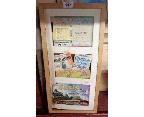 A framed collection of festival and gig tickets including Glastonbury, Michael Jackson, Oasis, etc.