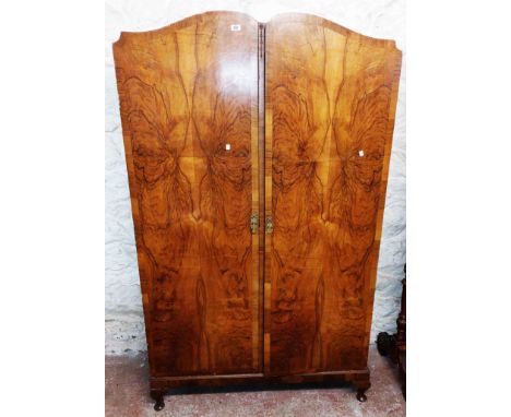 A 1.2m 1930's walnut book matched veneered double wardrobe with hanging space, shelf and drawer, set on short cabriole legs w