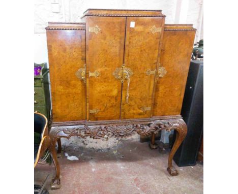 A 1.32m vintage walnut break-top cabinet with fitted drinks and mirrored interior and flanking cupboard doors, set on an acan