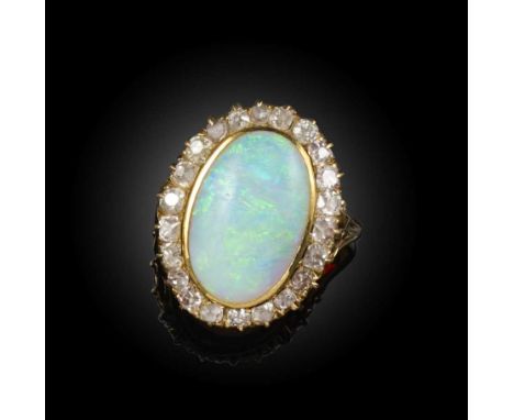 A late Victorian opal and diamond ring, the solid white opal set within a surround of diamonds in yellow gold, size M, case