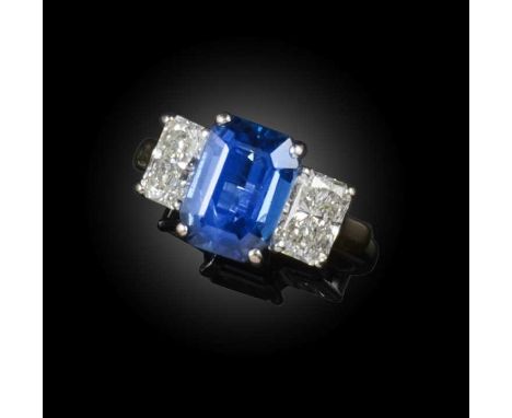 A sapphire and diamond three stone ring, the step-cut sapphire flanked with diamonds in platinum and yellow gold, size J