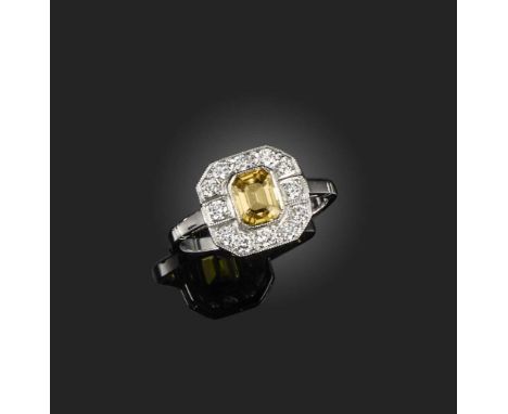 A yellow sapphire and diamond ring, of geometric design, set with a step-cut yellow sapphire weighing 1.20 carats, and brilli