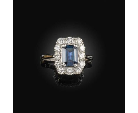 A sapphire and diamond ring, of cluster design, centring on a step-cut teal sapphire, within a border of brilliant-cut diamon