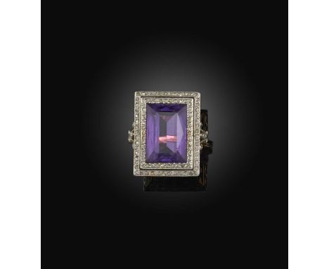 An amethyst and diamond ring, early 20th century, set with a rectangular step-cut amethyst, to a border and fleur-de-lis shou