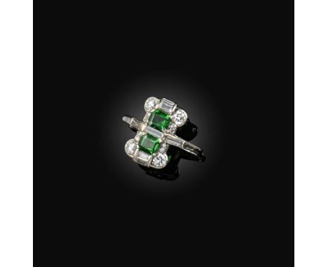 An Art Deco tsavorite garnet and diamond ring, circa 1920 and later, of geometric design, set with two step-cut tsavorite gar