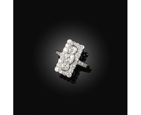 A diamond ring, early 20th century, designed as a rectangular openwork plaque, set with a vertical line of oval and circular-