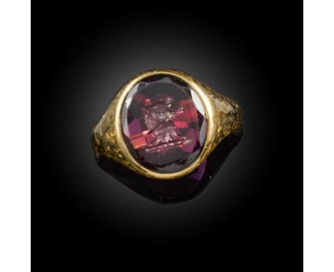 A garnet intaglio signet ring, 20th century, set with a garnet intaglio depicting a crest of a bull holding an arrow in its m