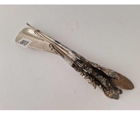 Four button hooks one with Mr Punch and a shoe horn