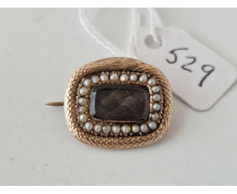 A antique Victorian gold mourning brooch with snake surround and a pearl and glazed centre