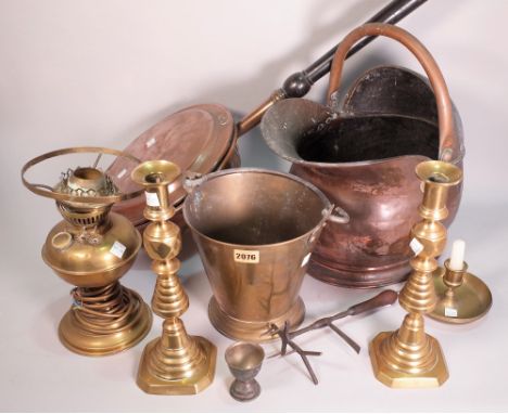 Copper and brass including a coal scuttle, a warming pan, a pair of candlesticks, a bucket, an oil lamp and a large shell cas