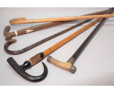 A group of five early 20th century walking sticksTo include a silver mounted stick and a horn mounted example the longest 93c