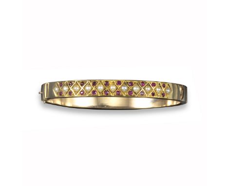 An Edwardian ruby and pearl bangle, of chequerboard design alternately-set with seed pearls and rubies in yellow gold, 5.5cm 