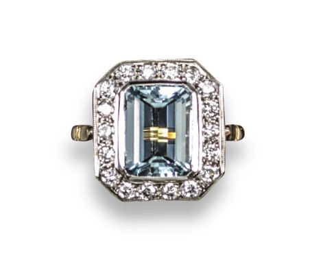 An aquamarine and diamond cluster ring, the emerald-cut aquamarine is set within a surround of eighteen round brilliant-cut d