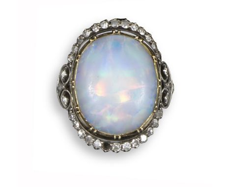 A late 19th century opal and diamond cluster ring, the oval opal cabochon set within diamond surround (one missing) in silver