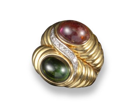 A tourmaline and diamond ring, set with a pink and green tourmaline cabochon conjoined with a swirl of graduated circular-cut