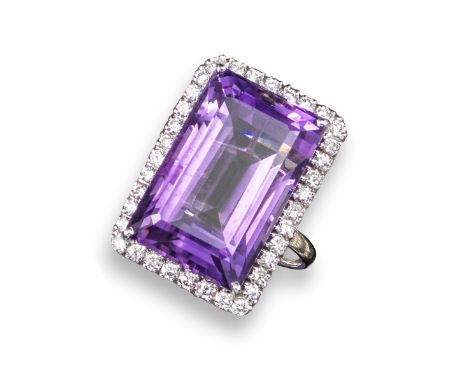 An amethyst and diamond ring, the rectangular step-cut amethyst is set within a surround of round brilliant-cut diamonds in 1