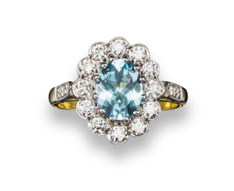 An aquamarine and diamond cluster ring, the oval-shaped aquamarine is set within a surround of twelve round brilliant-cut dia