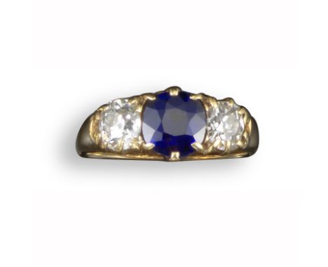 A late 19th century sapphire and diamond three-stone ring, the cushion-shaped sapphire flanked with old circular-cut diamonds