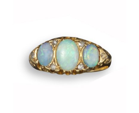 A Victorian opal and diamond ring, set with three graduated oval-shaped opals and diamond pointers in carved and pierced yell