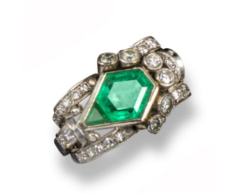 A mid 20th Century Odeonesque emerald and diamond ring, set with two central emeralds within scrolling border set with gradua