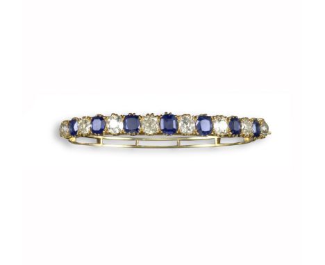 A Victorian sapphire and diamond bangle, alternately set with cushion-shaped sapphires and diamonds in yellow gold, 5.5cm inn