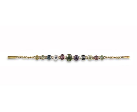 An Edwardian multi-gem-set gold bracelet, set with eleven graduated gem stones including tourmaline, garnet, sapphire and ame