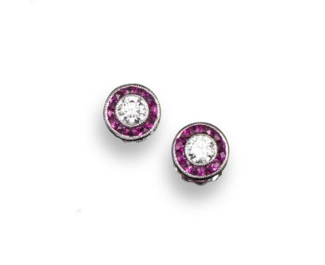 A pair of ruby and diamond ear studs, the circular-cut diamonds are set within a surround of tapered French-cut rubies in whi