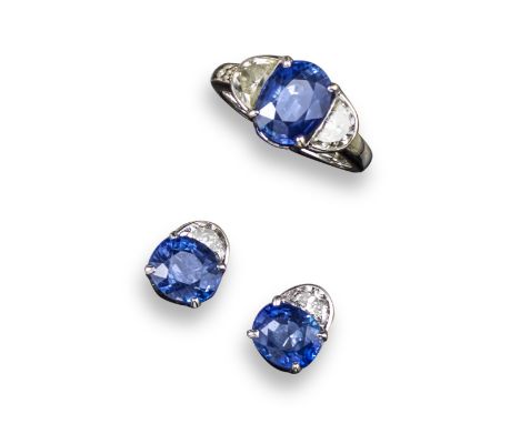 A sapphire and diamond three stone ring, the oval shaped sapphire is set with two half-moon-shaped shoulder diamonds, set in 