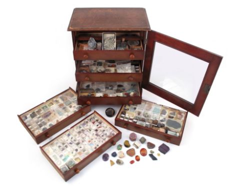 A wooden specimen cabinet, containing a variety of cased gemstones, including a large rough ruby and other smaller rough rubi