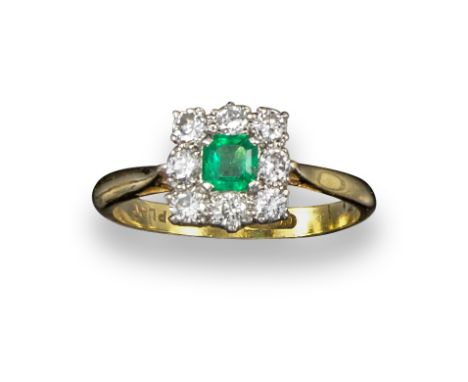 An emerald and diamond cluster ring, the emerald-cut emerald set within a surround of circular-cut diamonds in platinum and y