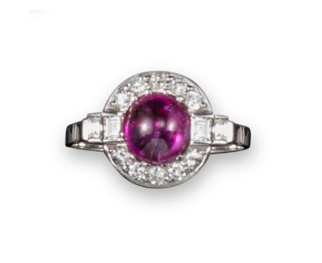 A ruby and diamond cluster ring, the ruby cabochon set within a surround of circular-cut diamonds and baguette-shaped shoulde