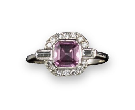 A pink sapphire and diamond cluster ring, the step-cut pink sapphire is set within a surround of round brilliant-cut diamonds