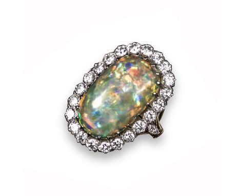 An opal and diamond cluster ring, the solid white opal cabochon is set within a surround of circular-cut diamonds in platinum